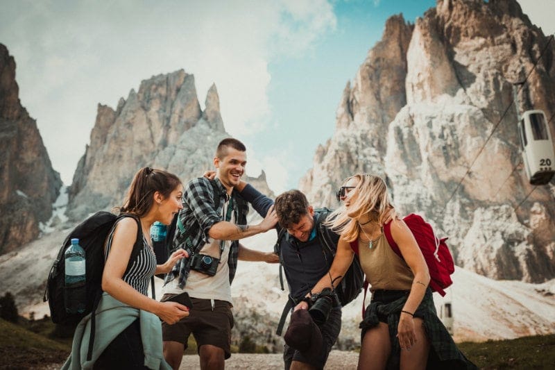 Four people laughing on a mountain